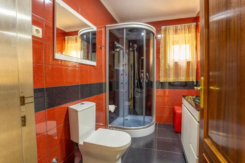 a bathroom with a toilet and a shower at A Casa dos Amigos - Termas São Vicente in Penafiel