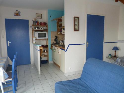 サン・マロにあるL'ESCALE - Résidence le Havre de Rotheneufの青い壁のキッチン、青いソファが備わります。