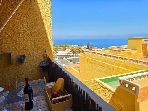a bottle of wine on a balcony with a view of the ocean at Arena Beach by HelloApartments in Puerto de Santiago