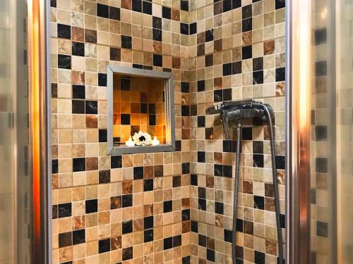 a bathroom with a shower with a tile wall at Sea View Playa Arena by HelloApartments in Puerto de Santiago