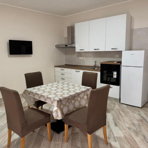 a kitchen with a table and chairs and a white refrigerator at Casa Vacanze Vienna in Boscotrecase