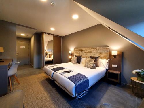 Un dormitorio con una cama grande en una habitación. en Apartahotel 5dos5, en Oviedo