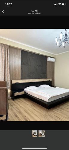 a bedroom with a large bed and a chair at Van Park Hotel in Shymkent
