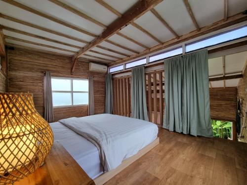 a bedroom with a bed and a large window at Tiny House Bali in Kerobokan