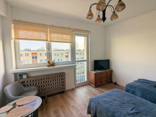 a bedroom with a bed and a window and a table at Komfortowa kawalerka w dobrym miejscu in Świnoujście