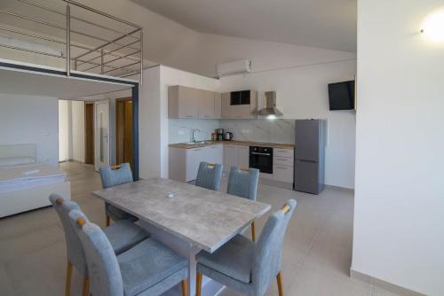 a kitchen and dining room with a table and chairs at B&B sv. Martin in Mali Lošinj