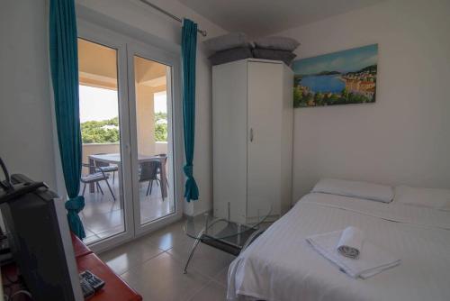 a bedroom with a bed and a balcony with a table at B&B sv. Martin in Mali Lošinj