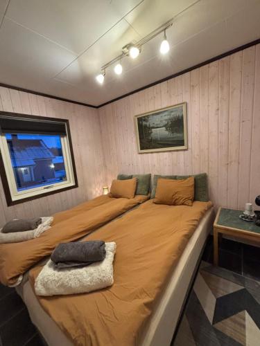 ein großes Bett in einem kleinen Zimmer mit Fenster in der Unterkunft Rimlige rom-kortidsleie 