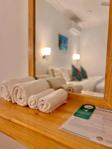 a room with a mirror and towels on a counter at Asseyri Guest House in Maradhoofeydhoo
