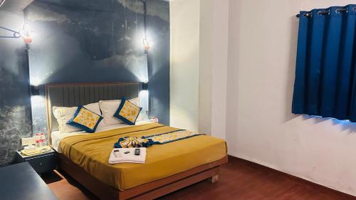 a bedroom with a bed with a purse on it at Hotel Cozy Inn in Kālundri