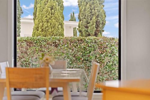 Una mesa y sillas frente a un seto con árboles. en Beautiful Spacious Home in a Serene Setting, en Eglinton