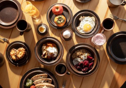 a wooden table topped with bowls of breakfast foods at Ski Resort & Hotel Pikku-Syöte in Syöte