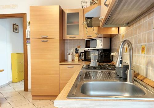 een keuken met een roestvrijstalen wastafel en een fornuis bij Holihome Sofy Mare in Tortoreto Lido