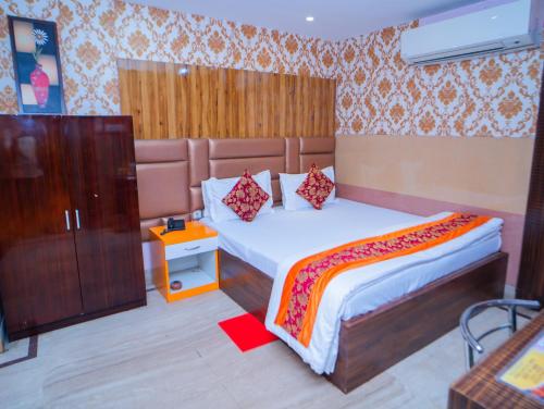 a bedroom with a large bed with a wooden headboard at Shreekrishna Hotels & Resorts Pvt Ltd in Kolkata