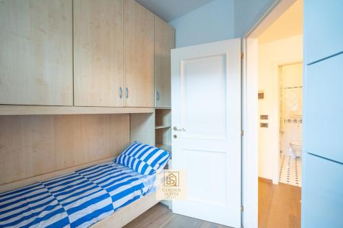 een kleine kamer met een bed en een witte deur bij GoldenSuitesItaly Piazza Duomo Luxury Apartment 3 in Trento