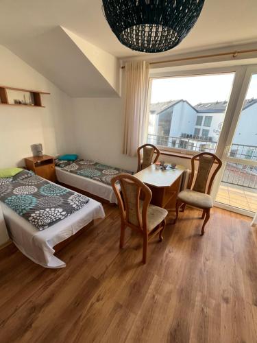 una stanza con due letti, un tavolo e delle sedie di Willa Lazur a Władysławowo