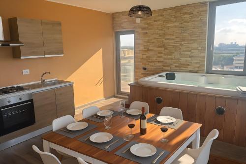 a kitchen with a table with chairs and a tub at Penthouse Station luxury apts Le dimore in Brindisi