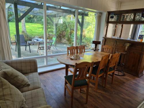 Una sala de estar con una mesa y sillas de madera. en Hawick - House - Sleeps 9 - Hot Tub, en Denholm