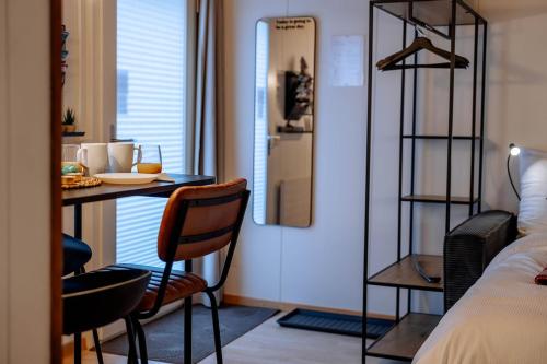 a room with a bed and a table and chairs at AlpinRetro-Apartment I Stylisch & zentral I See & Berge I Luzern I Zürich I Stoos I Rigi in Schwyz