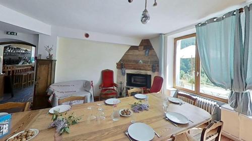 a dining room with a wooden table and a fireplace at CASA-Salon Bella Ciao Suite pour 5 personnes in Molines-en-Queyras