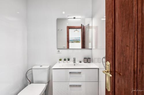 Un baño blanco con inodoro y lavabo. en Casa Tilola, en Los Llanos de Aridane