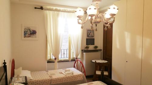 um quarto com 2 camas e um lustre em Casa Dolce Chiara em Assis