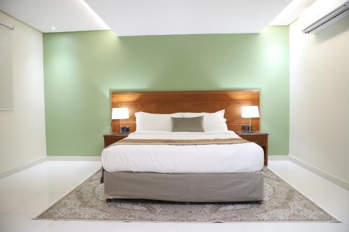 a bedroom with a large bed and two lamps at Medhal qurtuba by Prime hotels in Riyadh