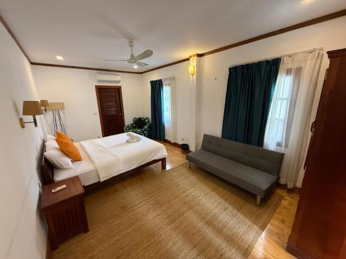 a hotel room with a bed and a couch at Banksy's Siem Reap in Phumĭ Réach Born (2)