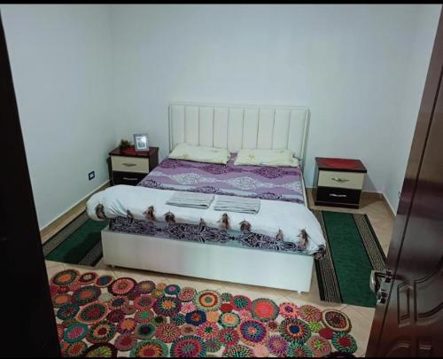 ein Schlafzimmer mit einem Bett und einem Teppich auf dem Boden in der Unterkunft SuperPanorama GuestHouse in Kukës