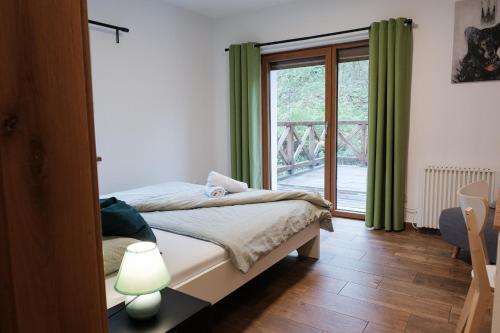 a bedroom with a bed and a large window at Apartmány Kamenice "Kamčatka" in Březová
