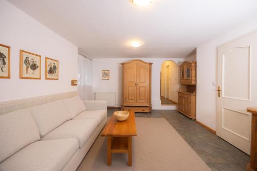 克拉尼斯卡戈拉Apartments Baki Kranjska Gora的客厅里有一张白色的沙发和一张桌子