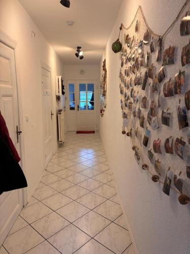 a hallway with a tile floor and a wall with shoes at Gut Ellernwurth in Wurster Nordseeküste