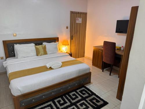a bedroom with a bed and a desk with a computer at Akure Airport Hotel in Oba Ile