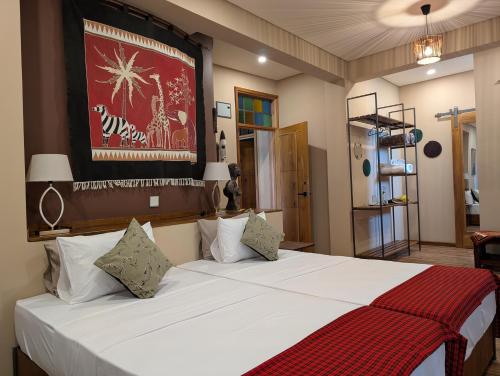 a bedroom with a large white bed in a room at Explorers Kilimanjaro Boutique Hotel in Moshi
