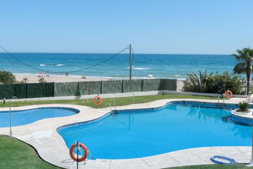 a swimming pool with the beach in the background at Apartamento 329 in Marbella