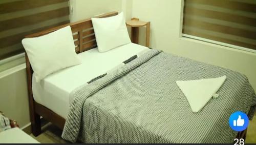 une chambre avec un grand lit blanc avec deux oreillers dans l'établissement Jerusalem Home Saty, à Idukki