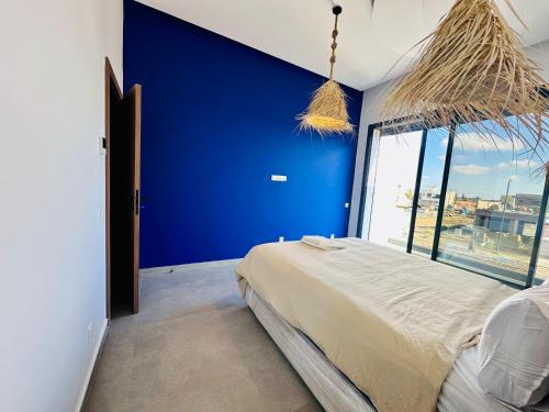 um quarto azul com uma cama e uma grande janela em Modern villa with a private pool em Marraquexe