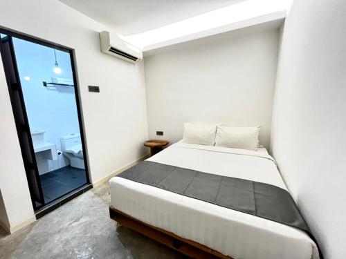 马六甲The White Loft Hotel Melaka的一间卧室，里面有一张床和一扇大窗户。