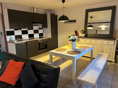 ein Wohnzimmer mit Tisch und Küche in der Unterkunft Appartement 80m2 3 chambres 5 lits in Vierzon