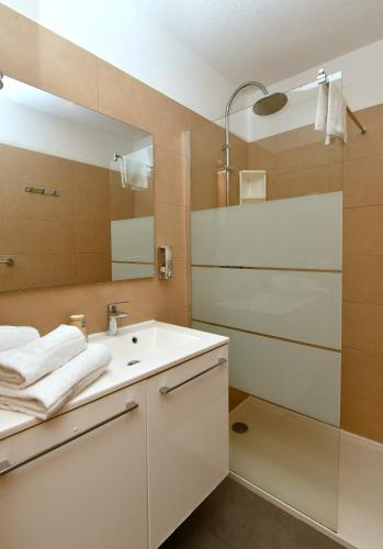 a bathroom with a sink and a mirror at Calvi Résidence, Appart'hôtel in Calvi