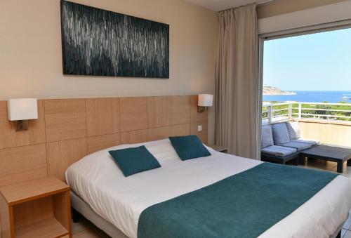 a hotel room with a bed and a balcony at Calvi Résidence, Appart'hôtel in Calvi