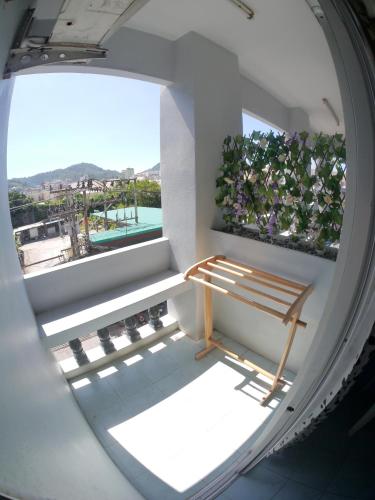 a room with a bench and a window with a plant at Adams house in Patong Beach