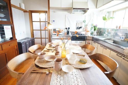 a kitchen with a wooden table with chairs and a tableablish at Max 29 ppl, Entire building, near ski resort,16 beds, 4 futons ,Washer and dryer!! in Yuzawa