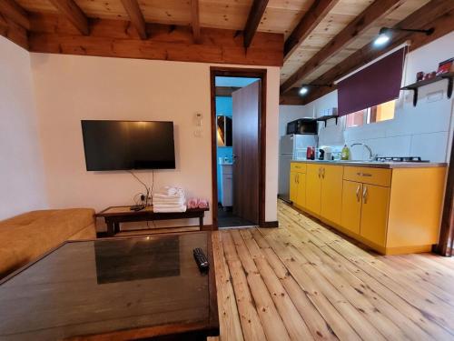 middle path في إيلات: غرفة معيشة فيها تلفزيون ومطبخ