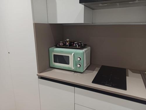 um micro-ondas verde em cima da bancada da cozinha em Ciauru al Sud em Messina