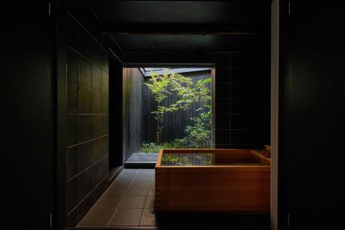 a bathroom with a bath tub with a window at Kikuyu No Yado in Kyoto