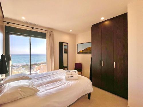 ein Schlafzimmer mit einem großen Bett und einem großen Fenster in der Unterkunft Luxury House Mirador Calaceite Torrox Costa, with Private Pool Jacuzzi and Wellness in Torrox Costa