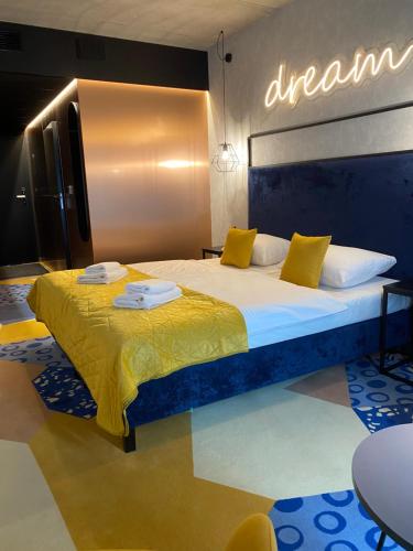a bedroom with a large bed with yellow pillows at SleepWell Apartments Czarna Góra in Sienna