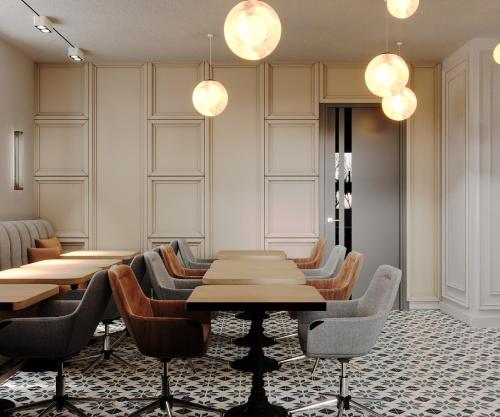 a dining room with tables and chairs and lights at Kurpark Suites in Bad Salzuflen