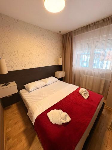 Un dormitorio con una cama grande con dos toallas encima. en NAR Royalton Apartment #01, en Niš